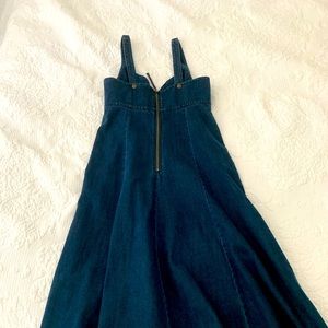 Cotton, adjustable straps, back zip, machine wash.